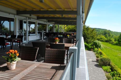a patio with chairs and tables on a roof at Zum Rebhang Bed & Breakfast in Oestrich-Winkel