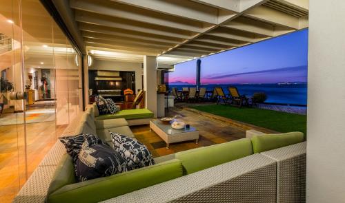 a living room with green furniture and a view of the ocean at 185 on BEACH Boutique Suites in Gordonʼs Bay