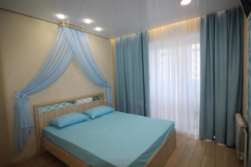 スィクティフカルにあるComfort apartment "Venice"のベッドルーム1室(青いカーテン、窓付)
