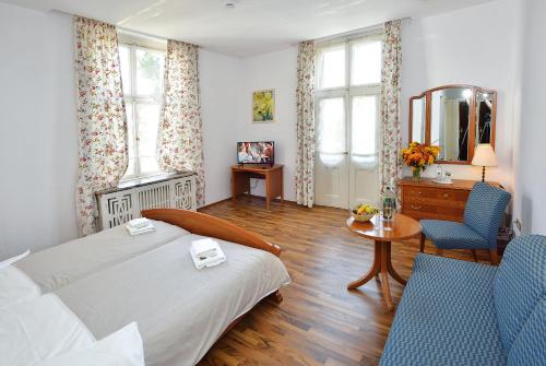 a bedroom with a bed and a table and a mirror at Villa Oranien in Diez