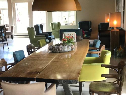 a dining room with a large wooden table and chairs at Hotel Lemmer in Lemmer