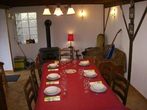 a dining room table with a red table cloth at Le Chant des Oiseaux in Vauquois