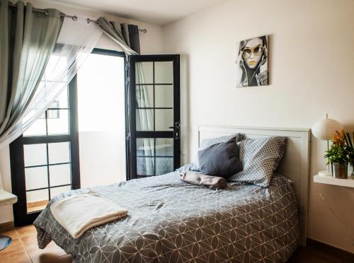 a bedroom with a bed with a person laying on it at Bhavana Surf House in Corralejo