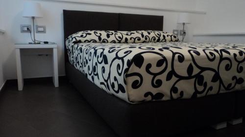 - un lit noir et blanc dans une chambre dans l'établissement Il Melograno B&B, à Castellaneta Marina