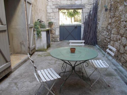 une table et deux chaises sur une terrasse dans l'établissement La Demeure Saint Clar, à Saint-Clar