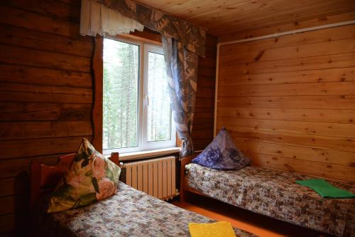 アルティバシュにあるGreen House at Teletskoye Lakeのログキャビン内のベッドルーム1室(ベッド2台付)