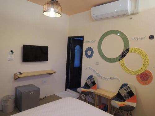 a room with a bed and two chairs and a television at Ktzyx in Nanwan