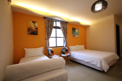 two beds in a room with orange walls at Ktzyx in Nanwan