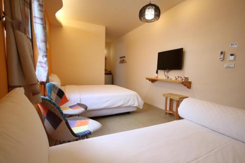 a hotel room with two beds and a tv at Ktzyx in Nanwan