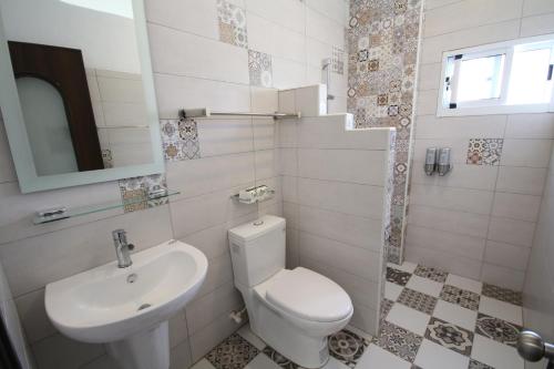 a white bathroom with a toilet and a sink at Ktzyx in Nanwan