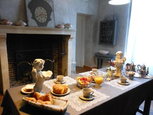 uma mesa com comida e lareira em Manoir de la Camusière em Unverre