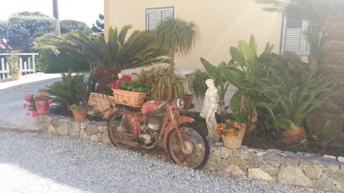 an old motorcycle parked in front of a house with plants at Villettemire in Capo Vaticano
