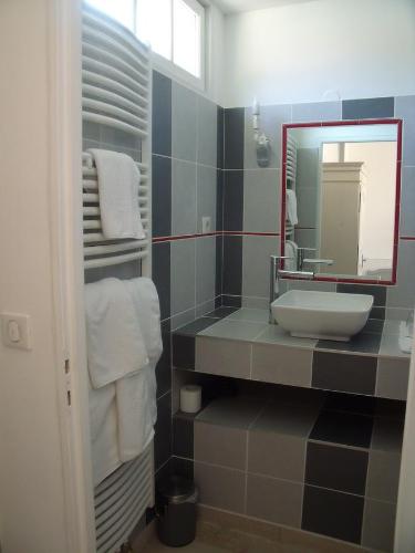 a bathroom with a sink and a mirror and towels at Ferme De La Canardière in Chantilly