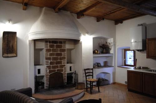 a living room with a brick fireplace in a house at Le Case Della Posta in Santo Stefano di Sessanio