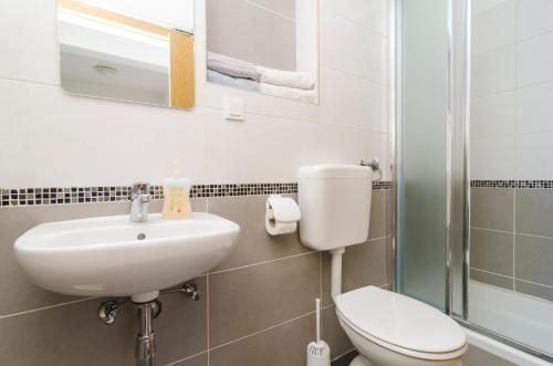 a bathroom with a sink and a toilet and a shower at Apartments Vitorin in Sobra