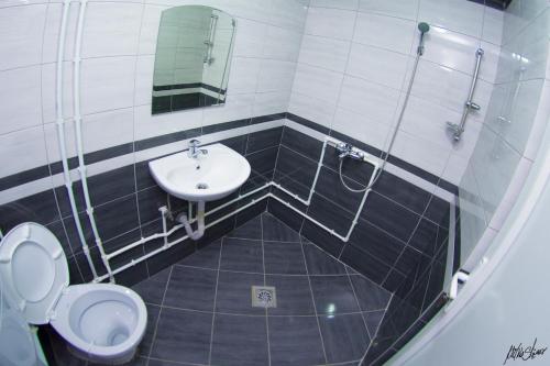 a bathroom with a sink and a toilet and a mirror at Apartmani Pe-Ko in Star Dojran