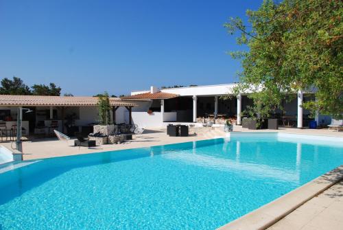 a large blue swimming pool in front of a building at Residence Ribellinu in Pianottoli-Caldarello