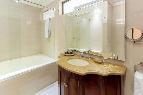 a bathroom with a sink and a shower and a tub at Hotel Embassy Park in Bogotá