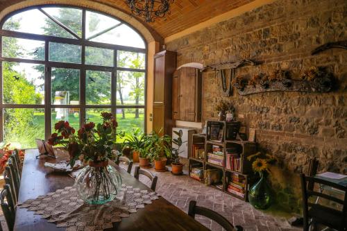 a dining room with a table and a large window at Agriturismo Il Brugnolo in Scandiano