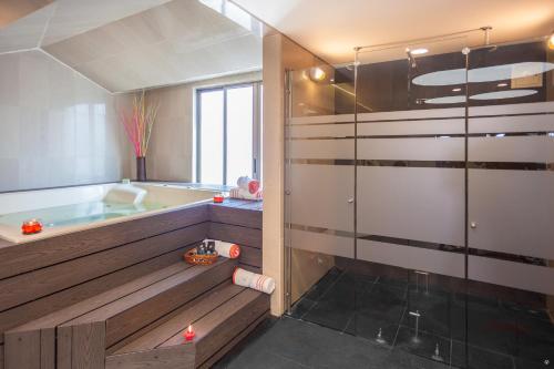 uma casa de banho com uma banheira e um chuveiro em vidro. em Hotel Embassy Park em Bogotá