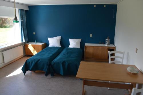 a bedroom with a bed with a blue wall at Djurs-BnB - Rimsøhuset in Rimsø