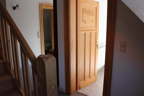 an open wooden door in a hallway with a stairs at Villa Jagdhaus in Wernigerode