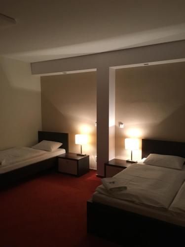 a hotel room with two beds and a mirror at Penzion Hermina in Veselí nad Moravou