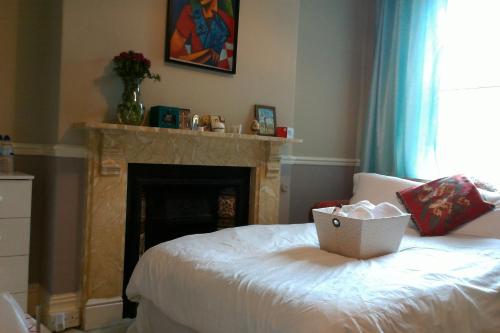 Un dormitorio con una cama y una chimenea con una caja. en Beautiful Victorian house, en Cardiff