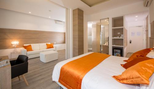 a bedroom with a bed and a desk and a couch at Hotel Aurora in Lido di Jesolo