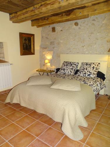 ValeillesにあるBergerie Le Vieux Manoirの石壁のベッドルーム1室(大型ベッド1台付)