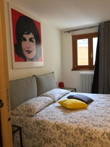 a bedroom with a bed with a yellow pillow on it at Appartamento Carducci in Madesimo