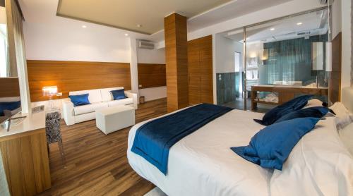 a bedroom with a large bed with blue pillows at Hotel Aurora in Lido di Jesolo