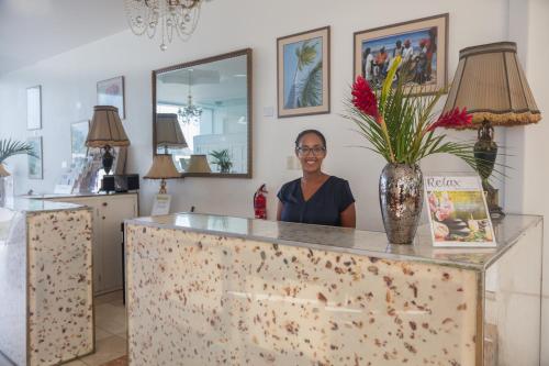 a woman standing behind a counter with a vase at Bacolet Beach Club in Scarborough