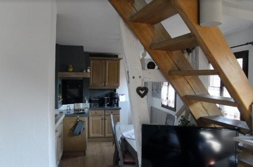 une cuisine avec un escalier menant à un loft dans l'établissement Maison Bleue, à Saverne