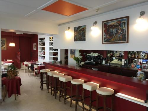 un restaurante con bar con taburetes en Hotel Restaurant Les Oceanides, en Concarneau