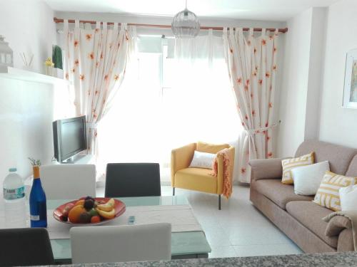 uma sala de estar com um sofá e uma mesa em Montaña Roja em El Médano