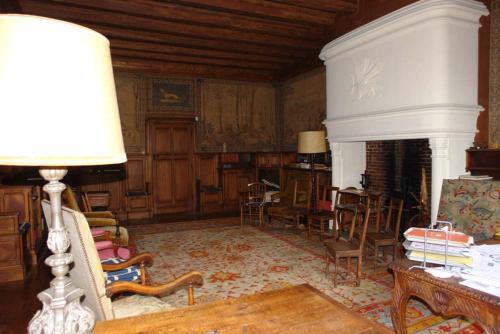 a living room with a table and chairs and a fireplace at Chateau du Donjon in Drumettaz-Clarafond