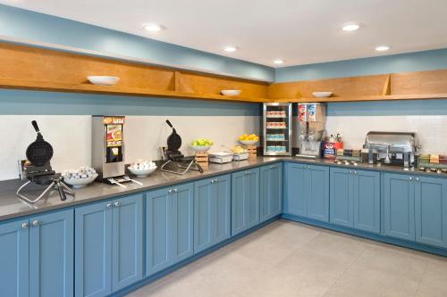 a large kitchen with blue cabinets and appliances at Country Inn & Suites Downtown Convention Center by Radisson, Gatlinburg, TN in Gatlinburg