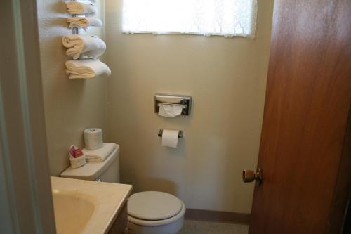 a bathroom with a toilet and a sink and towels at Hi-Lo Motel, Cafe and RV Park in Weed