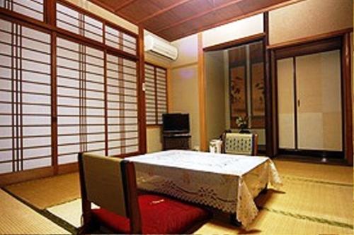 a bedroom with a large bed in a room at Ougiya Ryokan in Toyooka