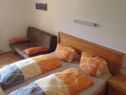 a bedroom with two beds with pillows and a couch at Pilznerhof in Strobl