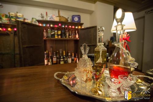 una mesa con una bandeja de vasos y una lámpara en Arkefthos Mountain Hotel, en Papigko