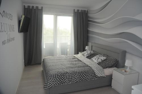 a bedroom with a bed and a striped wall at Apartament Solna 11 in Kołobrzeg