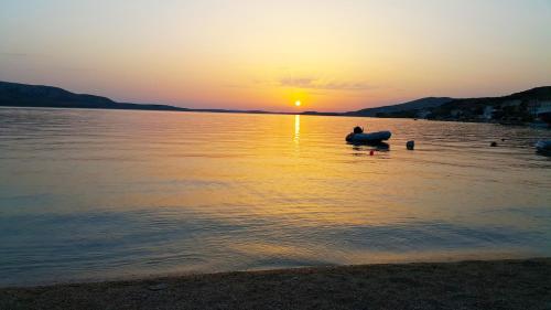 a person in a boat in the water at sunset at Big Pag apartament close to Zrće beach in Metajna