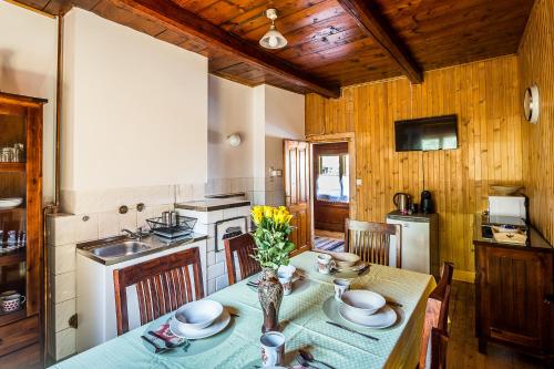 ザコパネにあるDomek Potocekのテーブルと椅子付きのキッチン、木製の壁のキッチン