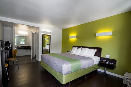 a bedroom with a large bed with a green wall at Fisherman's Cove Inn in Monterey