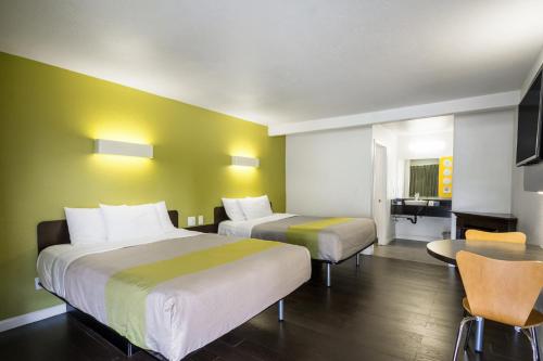 a hotel room with two beds and a table at Fisherman's Cove Inn in Monterey