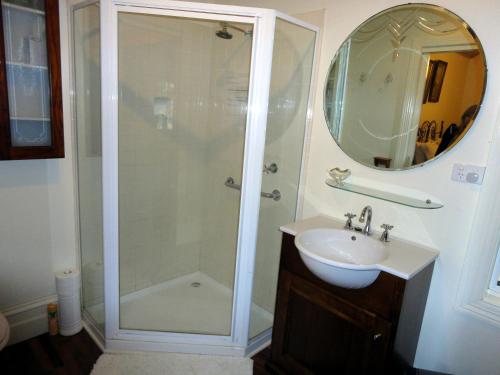 a bathroom with a shower and a sink and a mirror at Stone's Throw Cottage Bed and Breakfast in Belgrave