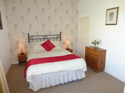 um quarto com uma cama com almofadas vermelhas e brancas em The Dales em Stanhope