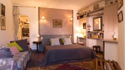 ein Wohnzimmer mit einem Bett und einer Couch in der Unterkunft La Cordière in Lourmarin